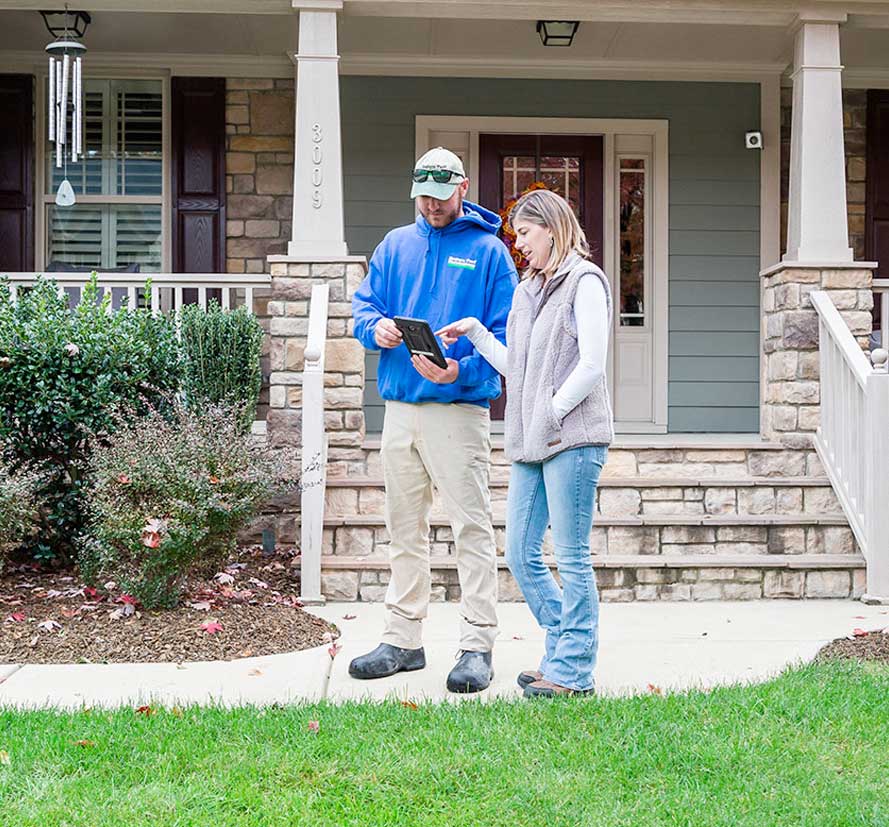 Green group employee showing tablet screen to a homeowner