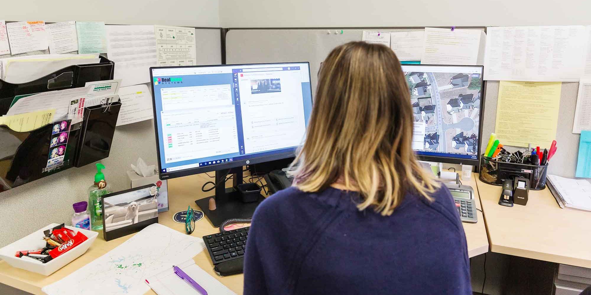 lawn-care-software A woman sitting at a desk in front of a computer screen