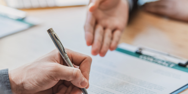 Selling A Business Closeup of hands signing a legal document